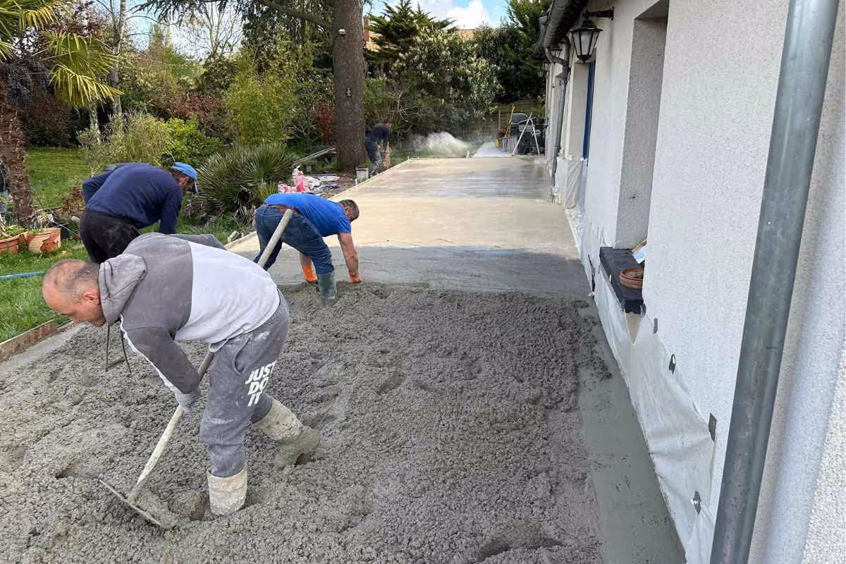 Pose d'une dalle de béton décoratif extérieur avec ouvriers